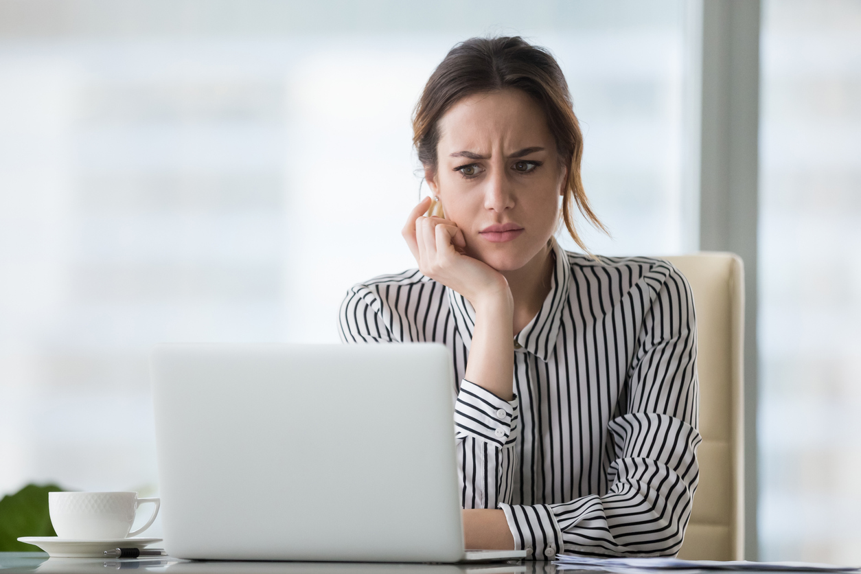 woman looks at computer in a concerned or confused way