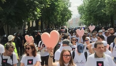 people walking in Moldova Pride holding big pink hearts overhead